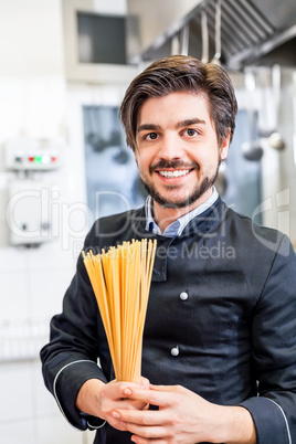 Attractive friendly chef preparing spaghetti