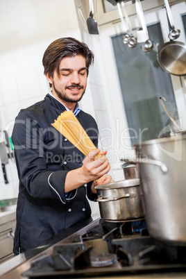 Attractive friendly chef preparing spaghetti