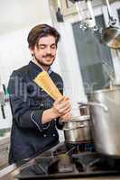 Attractive friendly chef preparing spaghetti