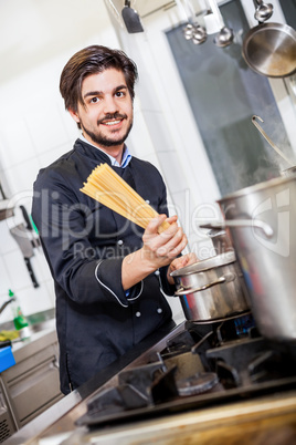 Attractive friendly chef preparing spaghetti