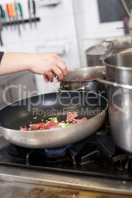 Chef or braising meat in a frying pan