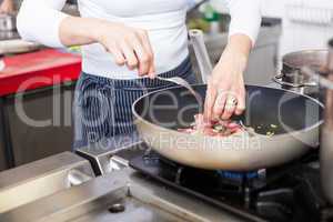 Chef or braising meat in a frying pan