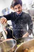 Chef cooking a vegetables stir fry over a hob