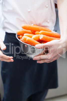 Chef in uniform preparing fresh carrot batons