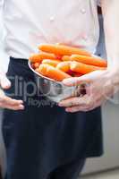 Chef in uniform preparing fresh carrot batons