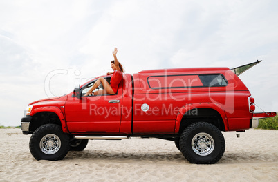 Sexy woman travelling on the red jeep