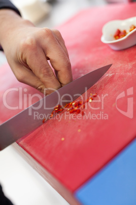 Chef dicing red hot chili peppers