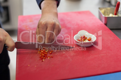 Chef dicing red hot chili peppers