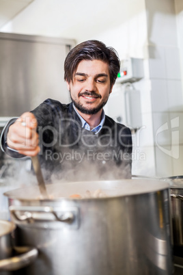 Chef cooking a vegetables stir fry over a hob