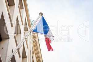 Flag of France fluttering under a serene blue sky