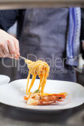 Chef plating up seafood pasta