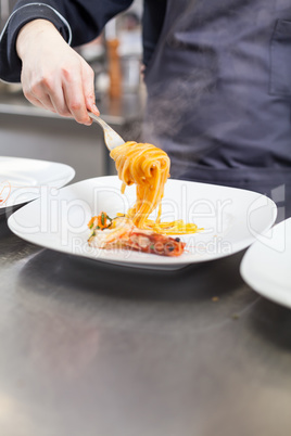 Chef plating up seafood pasta