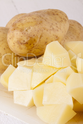 Whole Potatoes and Chopped Pieces on Cutting Board