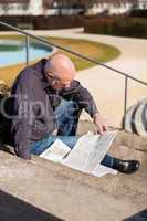 Man sitting on steps reading a newspaper