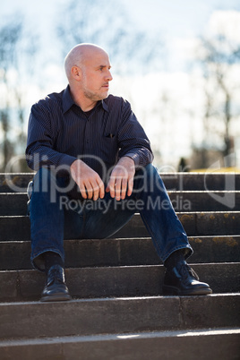 Thoughtful man sitting on a flight of steps