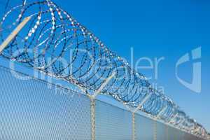 Coiled razor wire on top of a fence