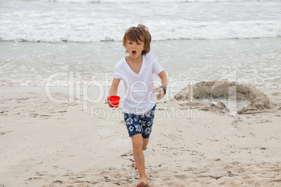 cute little boy playing in sand on beach in summer