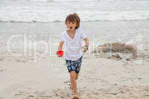 cute little boy playing in sand on beach in summer
