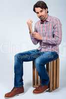 Handsome young man sitting on a wooden box