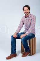 Handsome young man sitting on a wooden box