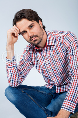 Handsome young man sitting on a wooden box