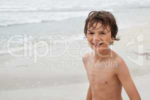 smiling little kid boy child on the beach in summer vacation