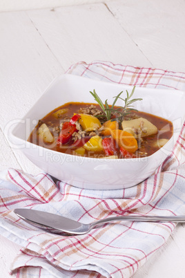 Hearty Stew in Bowl and Spoon on Plaid Dish Towel