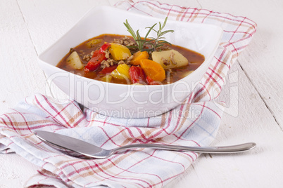 Hearty Stew in Bowl and Spoon on Plaid Dish Towel