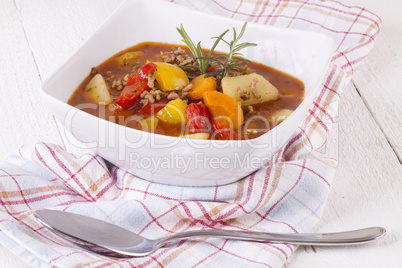 Hearty Stew in Bowl and Spoon on Plaid Dish Towel