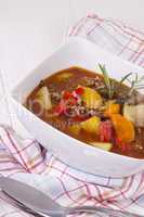 Hearty Stew in Bowl and Spoon on Plaid Dish Towel