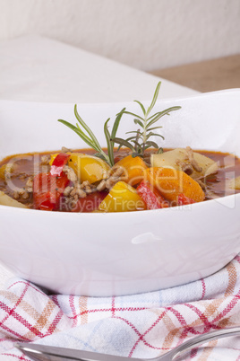 Hearty Stew in Bowl and Spoon on Plaid Dish Towel