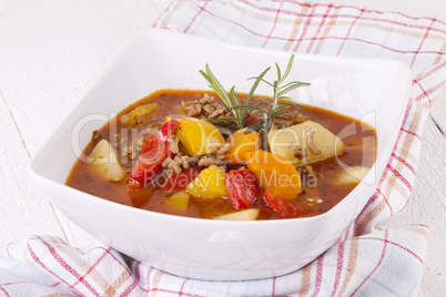 Hearty Stew in Bowl and Spoon on Plaid Dish Towel