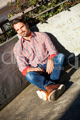 Man sitting on the ground with feet crossed