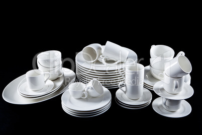 mixed white dishes cups and plates isolated on black