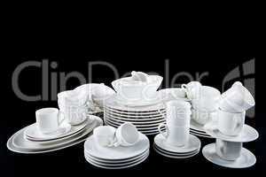 mixed white dishes cups and plates isolated on black