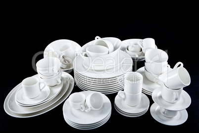 mixed white dishes cups and plates isolated on black