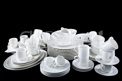 mixed white dishes cups and plates isolated on black