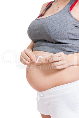 Pregnant woman breaking a cigarette in two