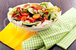 fresh mixed colorful salad on wooden table