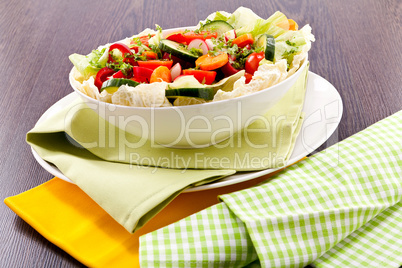 fresh mixed colorful salad on wooden table