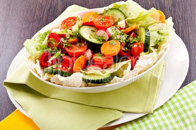 fresh mixed colorful salad on wooden table