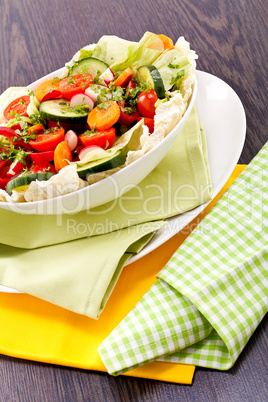 fresh mixed colorful salad on wooden table