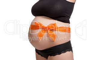 Pregnant woman wearing a bow on her belly