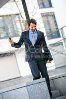 Smiling businessman walking down stairs