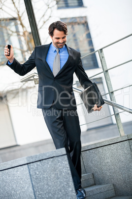 Smiling businessman walking down stairs
