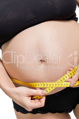 Pregnant woman measuring her abdomen