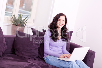 smiling woman on couch with notebook