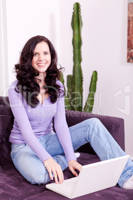 smiling woman on couch with notebook