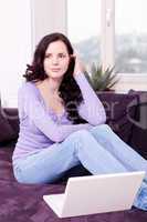 smiling woman on couch with notebook