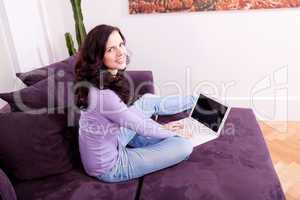 smiling woman on couch with notebook